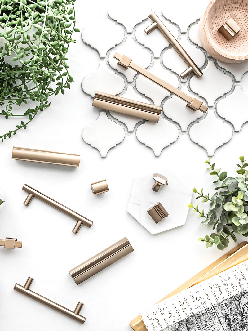 Cabinet handles on a white surface with decorative tiles and plants